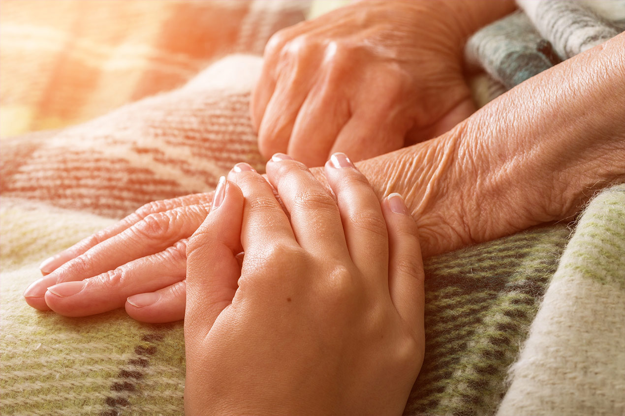Hospiz Junge Hand die eine alte Hand im Hospiz hält